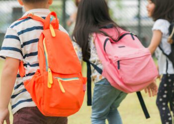 Crianças indo para escola com mochilas pesadas